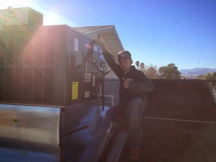 HVAC technician performing Boiler Repair on a rooftop unit in Florence